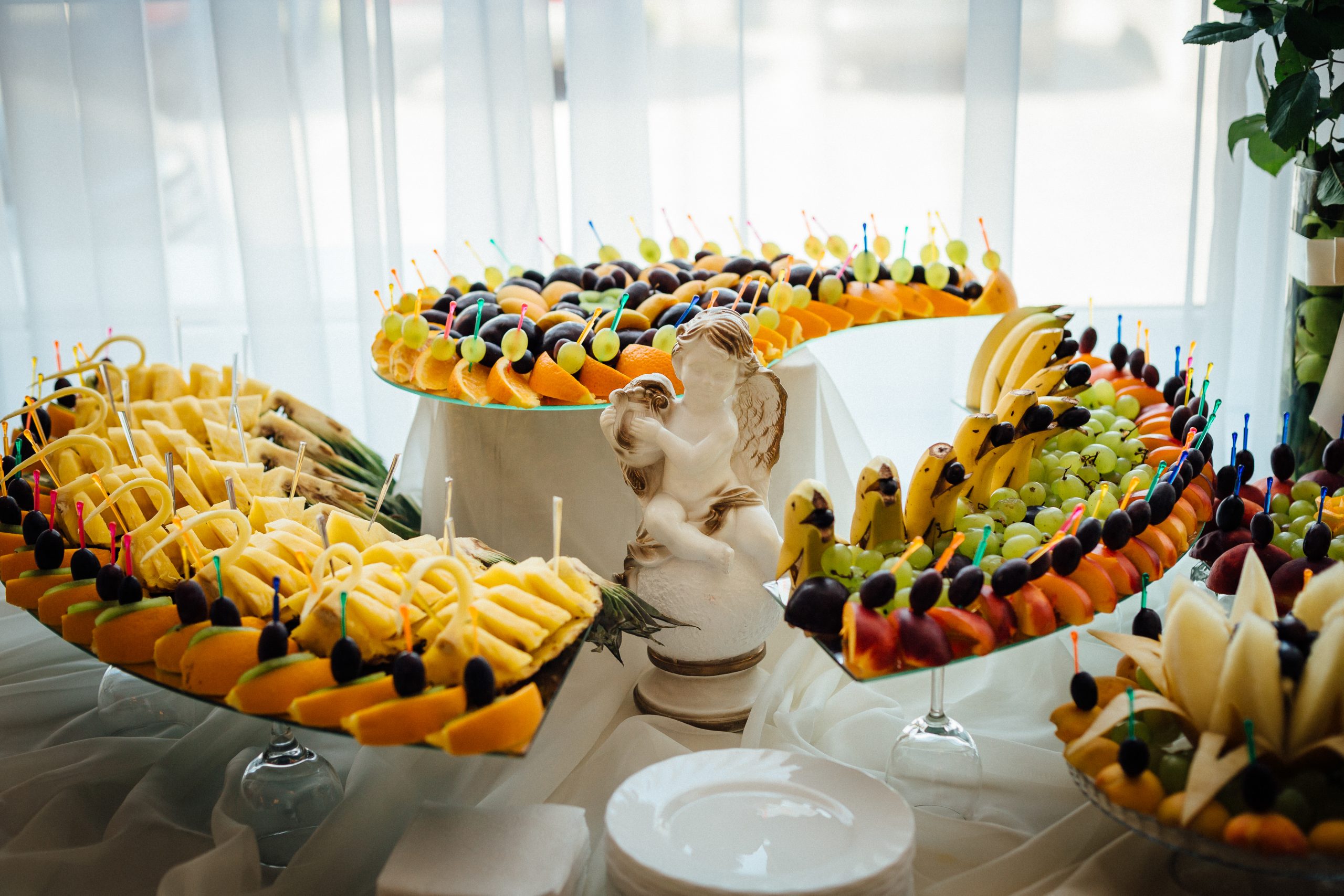 Cut fruits lie served on curved trays